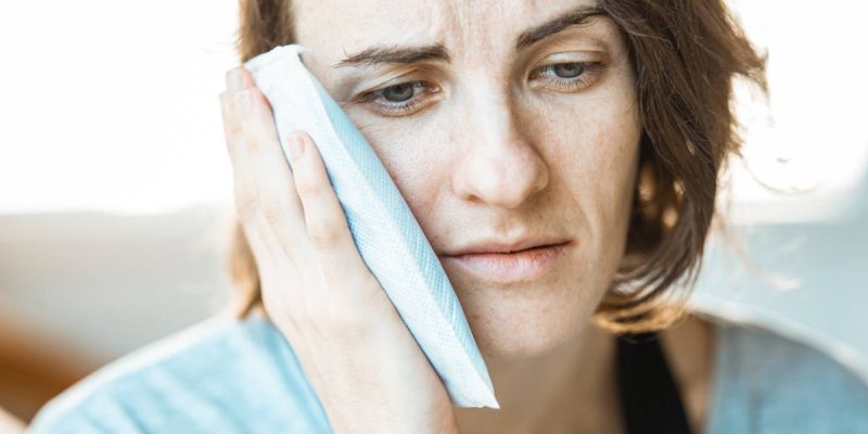 Woman showing signs of jaw pain.