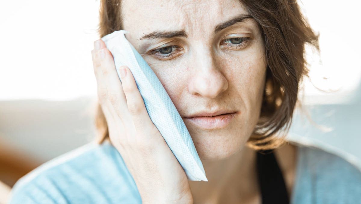 Woman showing signs of jaw pain.