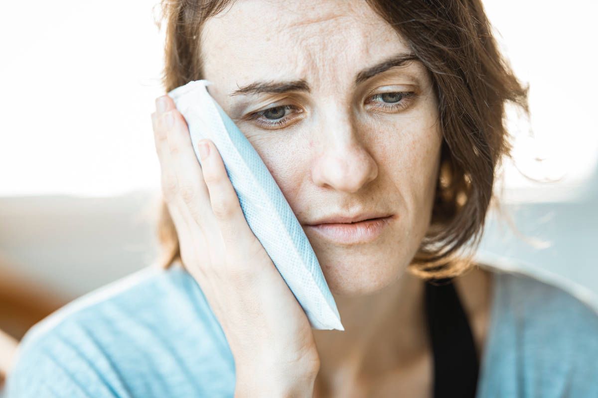 Woman showing signs of jaw pain.